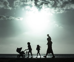 Silhouette of mother pushing baby cart with family 