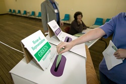 A person casting her vote into a ballot box during an election.