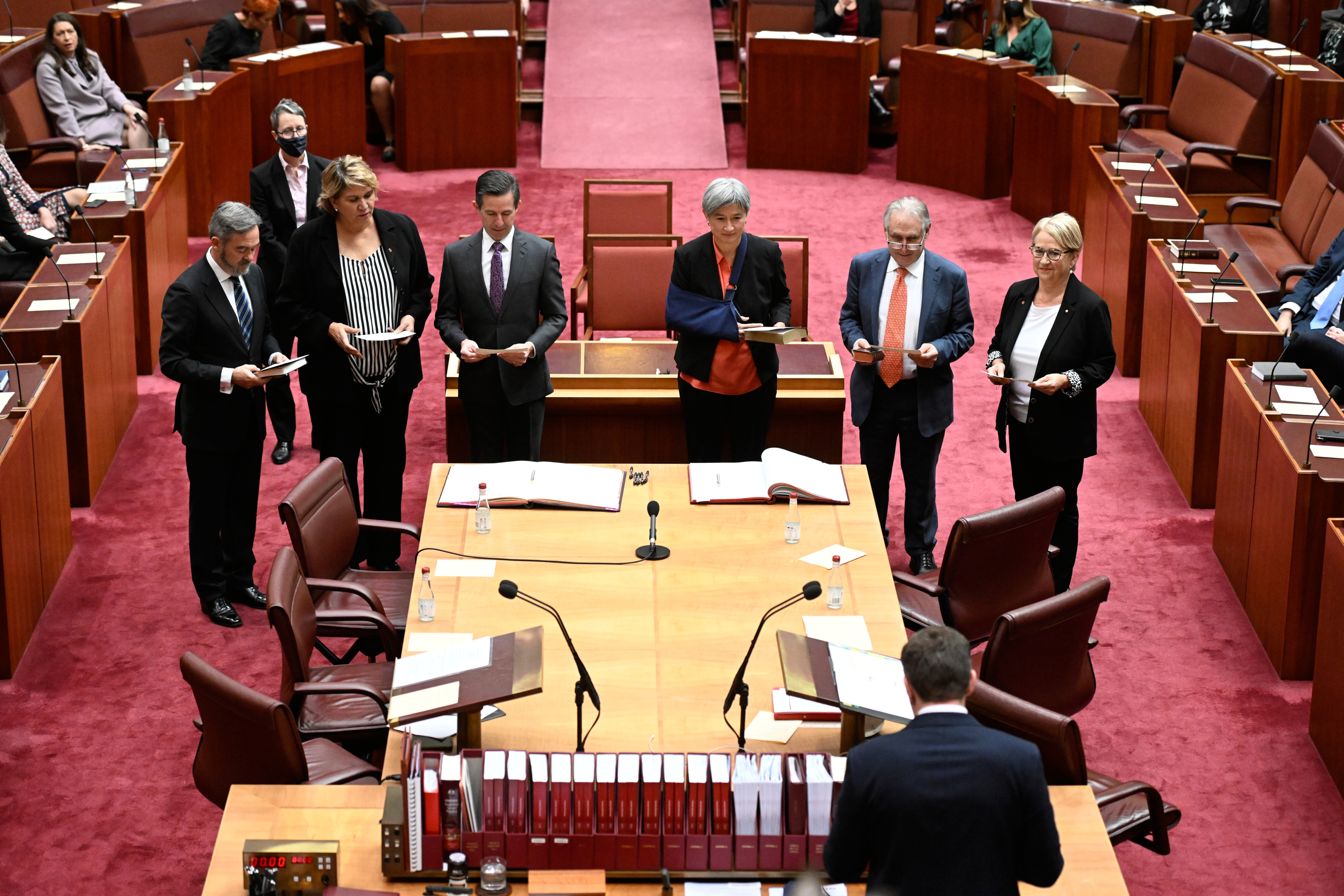 Six senators standing making an oath or affirmation in the Senate chamber