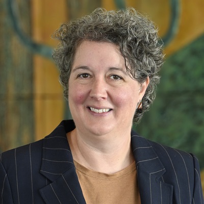 Headshot of a lady dressed in a navy business suit.