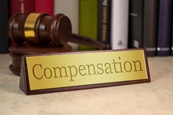 Golden sign with gavel and the word compensation etched into the sign