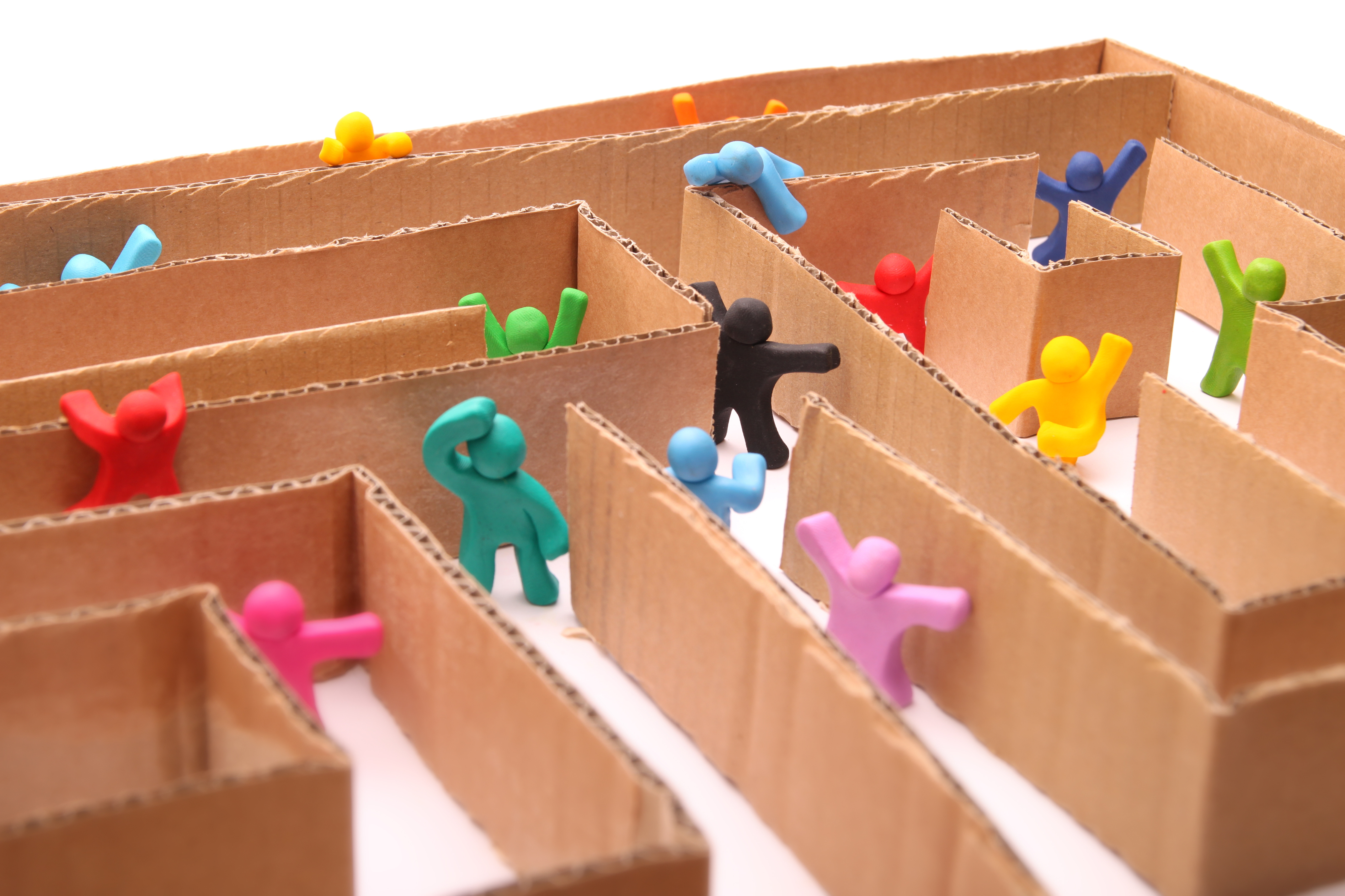 A maze made of cardboard, with tiny figures inside, attempting to escape.