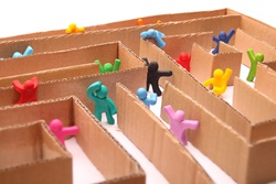A maze made of cardboard, with tiny figures inside, attempting to escape.