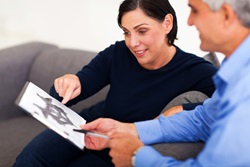 mature female patient looking at Rorschach inkblot with psychologist in office
