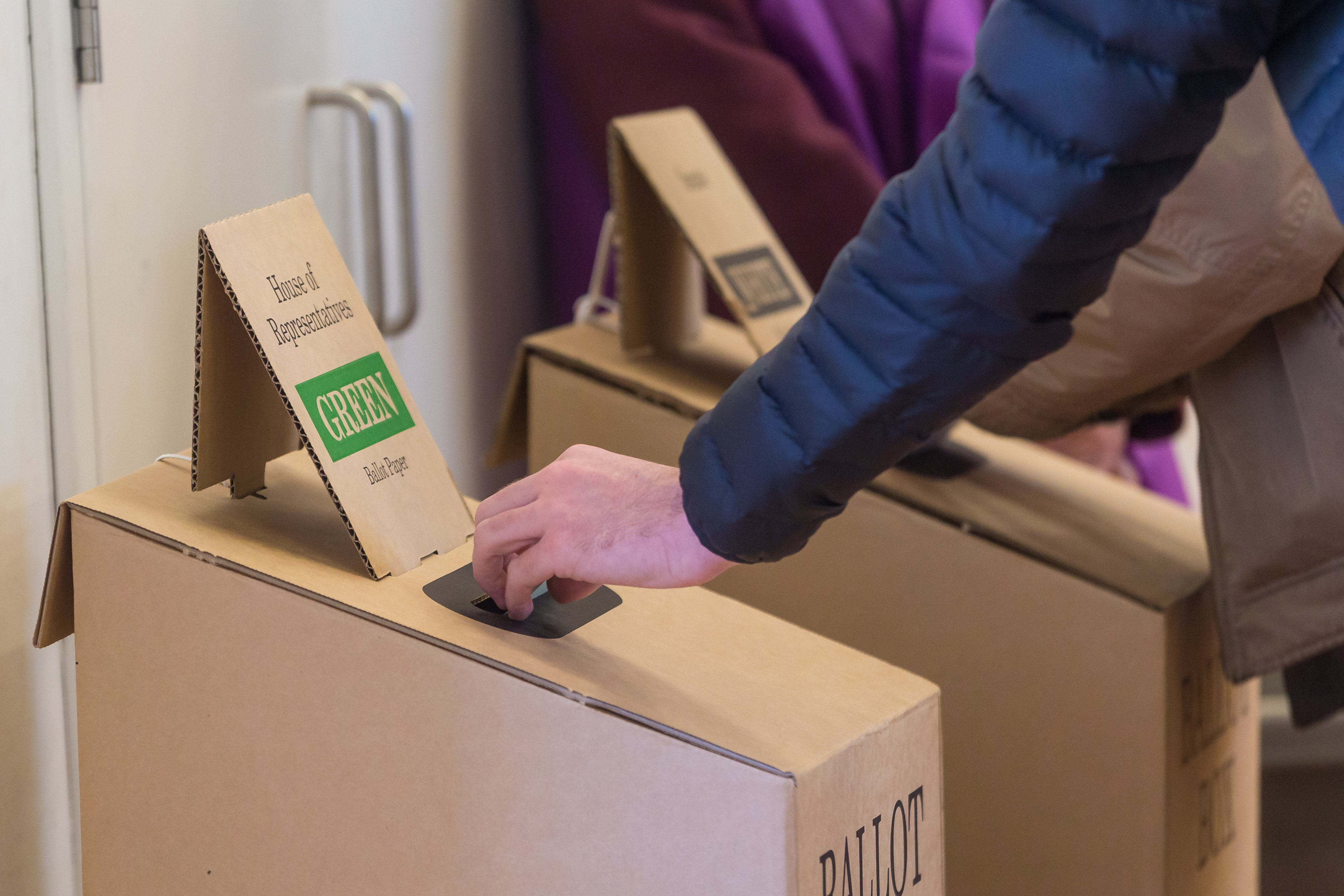 Man places voting paper into ballot box