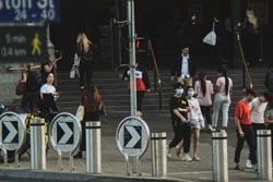 People walking  on pedestrian crossing in Melbourne, some wearing masks