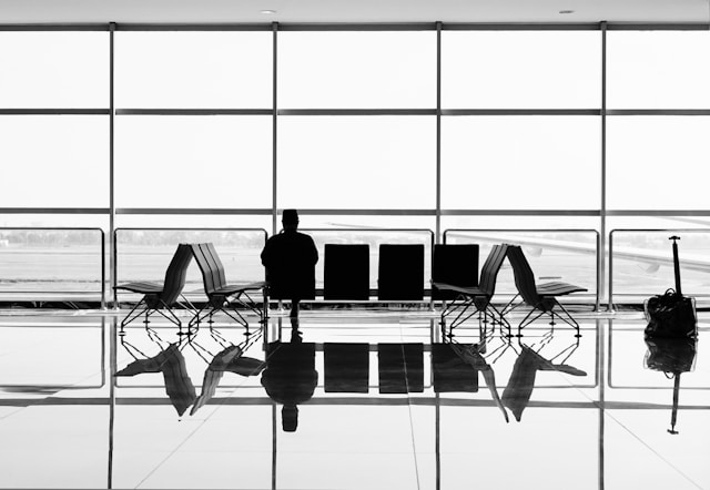 Man sitting alone on an gang chair in an airport