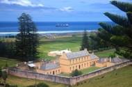 Convict era buildings & jail at Kingston, Norfolk Island. Cargo ship offshore being unloaded via Lighter boats
