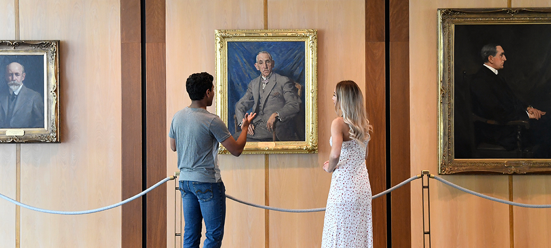Visitors discuss a portrait of former prime minister Billy Hughes