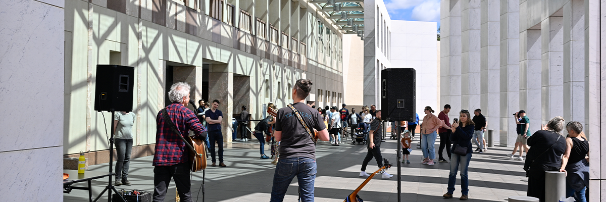 Photo of people playing music in front of Parliament House