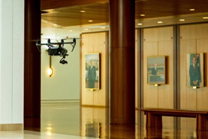 A drone flying past artwork in the Members Hall