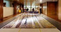Student volunteers from the University of Canberra help to clean the Great Hall Tapestry