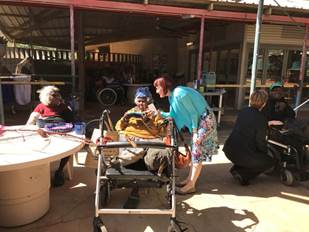 Figure 1.3 & 1.4 (from left to right): Senator Siewert speaks to residents and artists about the baskets they are creating, while Senator Reynolds speaks with Leslie who participates on the local radio station; and image of former residents' art on one of the pathways in the facility.