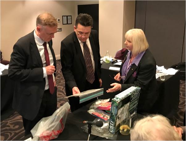 Mrs Vicki Hamilton, OAM, Chief Executive Officer; Secretary, Asbestos Council of Victoria/GARDS Inc showing Senator Ketter and former Senator Xenophon samples of products containing illegally imported asbestos including crayons and beaded jewellery.