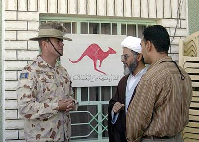 Figure 5.3 Lieutenant Colonel Roger Noble , Commanding Officer of the AMTG, and community leader Sheikh Abdullah Aziz (centre) discuss the benefits of the community centre at As Salman, a “Red Kangaroo” project